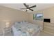 Neutral bedroom with a ceiling fan, window, and television with storage at 32 Long Meadow Ln, Rotonda West, FL 33947