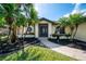 Attractive home exterior adorned with palm trees, tasteful landscaping, and a welcoming entryway at 32 Long Meadow Ln, Rotonda West, FL 33947