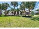 Charming front yard with palm trees and beautiful landscaping, providing excellent curb appeal at 32 Long Meadow Ln, Rotonda West, FL 33947