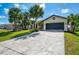 Well-manicured front yard with lush grass and a circular driveway to an attached 2-car garage at 32 Long Meadow Ln, Rotonda West, FL 33947