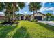 Charming single-story home with lush lawn, tropical palm trees and manicured landscaping at 32 Long Meadow Ln, Rotonda West, FL 33947