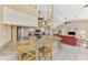 Open kitchen with granite counters, stainless appliances, and adjacent living area with bright red sofa at 32 Long Meadow Ln, Rotonda West, FL 33947