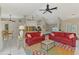 Bright open floor plan with two red sofas and view of kitchen and dining area at 32 Long Meadow Ln, Rotonda West, FL 33947