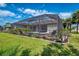 Screened-in pool area with lounge chairs and well-maintained landscaping at 32 Long Meadow Ln, Rotonda West, FL 33947