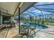 Beautiful screened-in pool and spa with patio seating and canal view at 32 Long Meadow Ln, Rotonda West, FL 33947