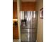 Modern stainless steel refrigerator with a water dispenser, set among wood cabinets and granite countertops at 3311 Purple Martin Dr # 126, Punta Gorda, FL 33950