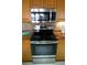 Close-up of a stainless steel oven and microwave with wood cabinets and decorative tile backsplash at 3311 Purple Martin Dr # 126, Punta Gorda, FL 33950