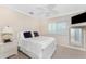 Bedroom showcasing a white bed, ceiling fan, and mirror mounted to the wall at 3657 Aruba Ct, Punta Gorda, FL 33950