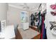 Bright walk-in closet featuring custom shelving, a vanity with a lighted mirror, and plush carpeting at 3657 Aruba Ct, Punta Gorda, FL 33950