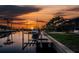 Boat lift on canal with orange sunset with palm trees and boat at 3657 Aruba Ct, Punta Gorda, FL 33950