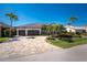 Elegant home featuring a three-car garage, paver driveway, and professionally landscaped front yard with tropical palms at 3657 Aruba Ct, Punta Gorda, FL 33950
