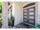 Stylish front entrance with stone accents, a modern door, and lush potted plants at 3657 Aruba Ct, Punta Gorda, FL 33950