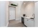 Hallway with tiled floors and features a wet bar with mini fridge and white cabinets at 3657 Aruba Ct, Punta Gorda, FL 33950