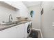 Bright laundry room featuring modern washer and dryer, sink, and cabinet space at 3657 Aruba Ct, Punta Gorda, FL 33950