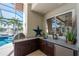 This beautiful outdoor kitchen has granite countertops, a mini-fridge, a stainless steel grill, and a sink at 3657 Aruba Ct, Punta Gorda, FL 33950