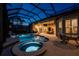 Beautiful pool and spa with chairs, outdoor furniture, and a summer kitchen in enclosed lanai at 3657 Aruba Ct, Punta Gorda, FL 33950
