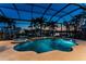 A beautiful screened-in pool features spa, waterfall, and lush tropical landscaping with canal views at 3657 Aruba Ct, Punta Gorda, FL 33950