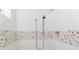 Contemporary shower showcasing textured white tiles with a decorative pebble accent band at 3657 Aruba Ct, Punta Gorda, FL 33950