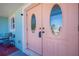 Charming light pink double front doors featuring oval glass inserts, accented by blue exterior paint at 4238 Gardner Dr, Port Charlotte, FL 33952