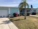Charming single-story home featuring a well-manicured lawn, tropical landscaping, and a screened porch at 4238 Gardner Dr, Port Charlotte, FL 33952
