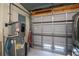 Attached garage with hot water heater, refrigerator and roll up door at 4238 Gardner Dr, Port Charlotte, FL 33952