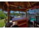 Thatched outdoor tiki bar overlooking the water, perfect for entertaining with seating and a grill at 4238 Gardner Dr, Port Charlotte, FL 33952