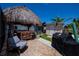 Backyard with tiled patio, poolside bar under thatched roof, BBQ, storage shed and grassy area at 4238 Gardner Dr, Port Charlotte, FL 33952