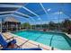 Beautiful screened-in pool with tiki hut, lawn ornaments, and waterfront view at 4238 Gardner Dr, Port Charlotte, FL 33952