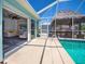 Screened-in pool with tiki hut and view into living room with sliders open to the pool area at 4238 Gardner Dr, Port Charlotte, FL 33952