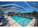 Enjoy this screened-in pool with waterfront views, a tiki hut and blue skies at 4238 Gardner Dr, Port Charlotte, FL 33952