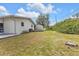 View of a spacious backyard and building with white painted exterior at 4477 Shady Ln, Punta Gorda, FL 33980