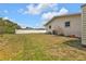 Lawn view of backyard with white fence and building exterior at 4477 Shady Ln, Punta Gorda, FL 33980