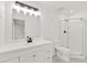 Bathroom with updated vanity and lighting, white cabinets, tiled floor, and glass enclosed shower at 4477 Shady Ln, Punta Gorda, FL 33980