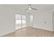 Bedroom with wood-look floors, fresh white walls, ceiling fan, sliding glass doors to Florida room and adjacent bathroom at 4477 Shady Ln, Punta Gorda, FL 33980