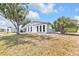 Single-story home on a sunny day with a xeriscaped front yard with mature trees at 4477 Shady Ln, Punta Gorda, FL 33980
