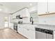 Updated kitchen featuring white cabinets, granite counters, stainless steel appliances, and a farmhouse sink at 4477 Shady Ln, Punta Gorda, FL 33980
