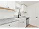 Updated kitchen featuring white cabinets, granite counters, stainless steel appliances, and a modern farmhouse sink at 4477 Shady Ln, Punta Gorda, FL 33980
