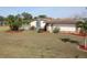 A home featuring a backyard and a patio area, complemented by a well-maintained lawn, landscaping, and palm trees at 474 Elm Nw Ave, Port Charlotte, FL 33952