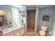Cozy bathroom with a tiled walk-in shower, vintage wallpaper, vanity with sink and toilet at 474 Elm Nw Ave, Port Charlotte, FL 33952