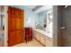 Bathroom with vanity and storage, tiled shower, mirror, and vintage-style jewelry box on the left of the sink at 474 Elm Nw Ave, Port Charlotte, FL 33952