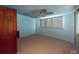 A clean and minimalist bedroom with a ceiling fan, light blue walls, and a light-colored carpet at 474 Elm Nw Ave, Port Charlotte, FL 33952