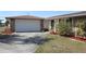 Charming home featuring a stone accent wall, well-maintained lawn, and attached two-car garage at 474 Elm Nw Ave, Port Charlotte, FL 33952