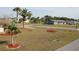 A cozy home with stone accents, complemented by a well-maintained lawn, landscaping, and palm trees at 474 Elm Nw Ave, Port Charlotte, FL 33952