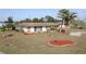 Charming home with a well-kept lawn and stone accents, complemented by neat landscaping and palm trees at 474 Elm Nw Ave, Port Charlotte, FL 33952