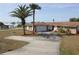 Single-story home featuring an attached two-car garage and a well-manicured front yard with palm trees at 474 Elm Nw Ave, Port Charlotte, FL 33952