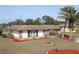 Charming home with a well-kept lawn and stone accents, complemented by neat landscaping and palm trees at 474 Elm Nw Ave, Port Charlotte, FL 33952