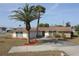 A well-maintained home with palm trees and stone accents, complemented by a spacious driveway and landscaping at 474 Elm Nw Ave, Port Charlotte, FL 33952