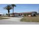 Desirable property featuring lush landscaping, a stone accent wall, and an attached two-car garage at 474 Elm Nw Ave, Port Charlotte, FL 33952