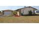 A single-story home featuring stone accents, a well-maintained lawn, and mature landscaping at 474 Elm Nw Ave, Port Charlotte, FL 33952