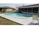 Inviting Kidney-shaped pool surrounded by a concrete deck and screened enclosure offers a private outdoor retreat at 474 Elm Nw Ave, Port Charlotte, FL 33952
